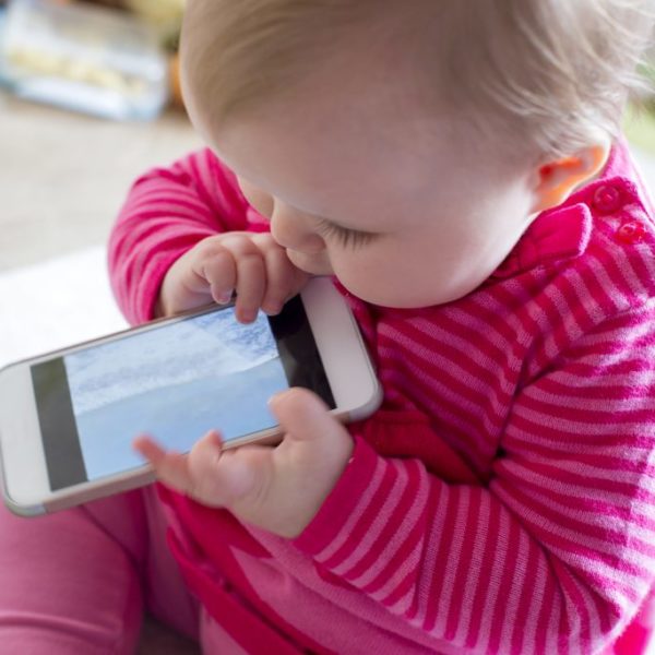 baby chewing on a mobile phone